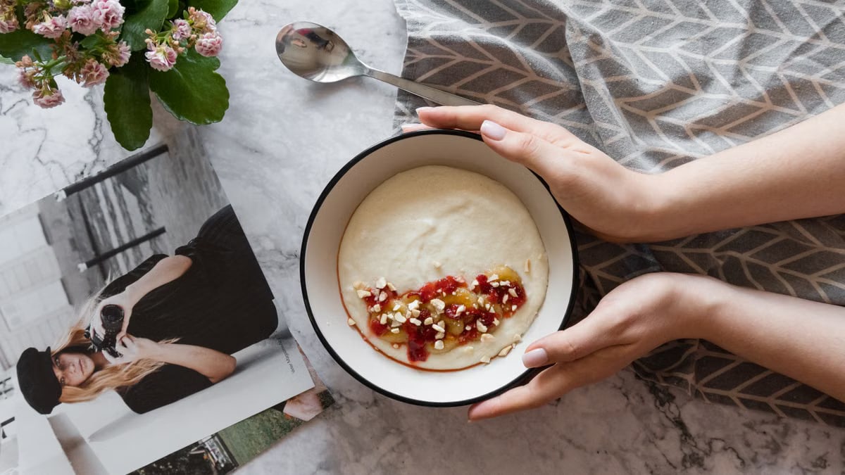 Delicious breakfast bowl with creamy cereals topped with fruit jam and nuts, perfect for a cozy morning.